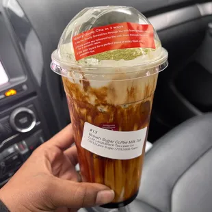 a hand holding a cup of iced coffee