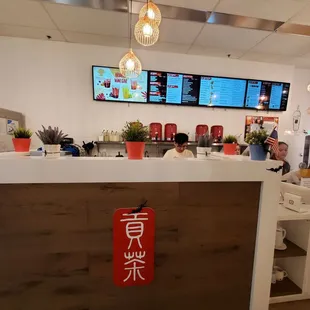 a restaurant counter with a menu in the background
