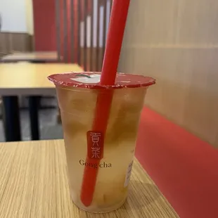 a cold drink in a plastic cup with a red straw