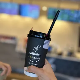 a hand holding a coffee cup