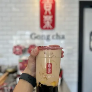 a hand holding a cup of cold coffee