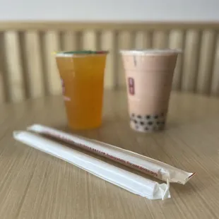 a cup of bubble tea and two strawberries