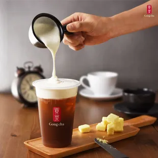 a person pouring milk into a cup