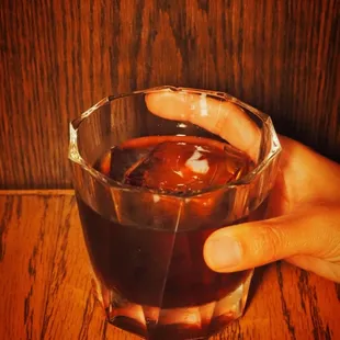 a person holding a glass of liquid