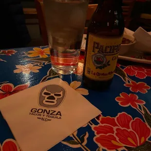 a glass of water and a bottle on a table