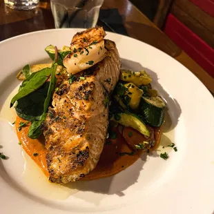 Scottish salmon with white shrimp, Romesco sauce, and roasted vegetables.