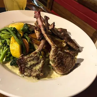 Grilled rack of lamb &quot;lollipops&quot; entree with potatoes Dauphinoise, garden vegetables, and creamy chimichurri sauce.