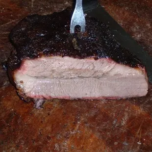 a piece of meat on a cutting board with a knife