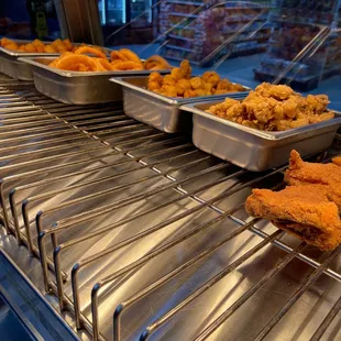 trays of fried chicken on a conveyor belt