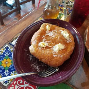 a plate of bread with butter and syrup