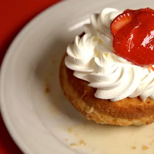 a cupcake with whipped cream and a strawberry on top