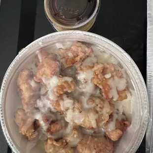 KFC over a bed of rice with cheese and sauces on the side
