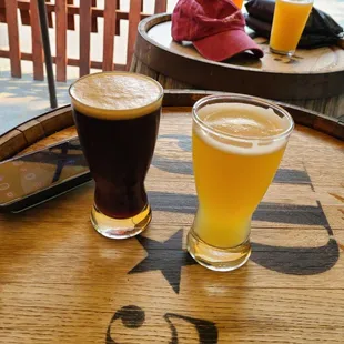 two glasses of beer on a barrel