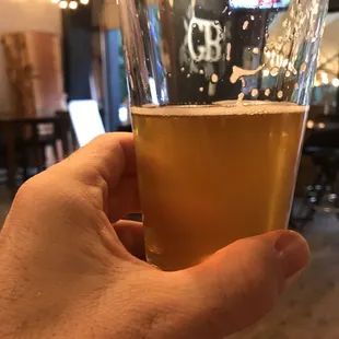 a hand holding a glass of beer