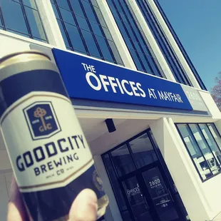 a hand holding a can of good city brewing