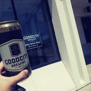 a hand holding a can of good city brewing
