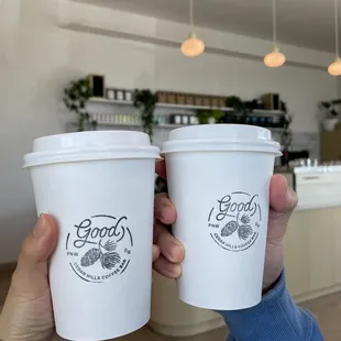 two people holding cups of coffee