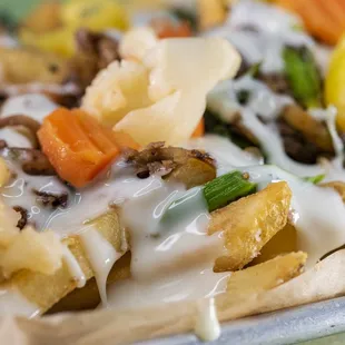 Philly Fries - french fries, provolone cheese sauce, shaved tri-tip steak with onions and peppers, broccoli rabe, housemade giardiniera