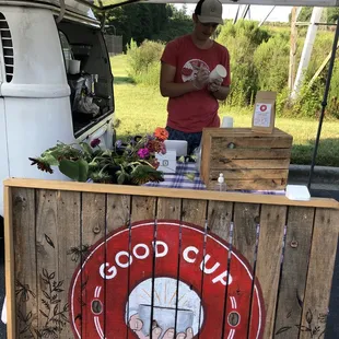 a man standing at a booth selling coffee