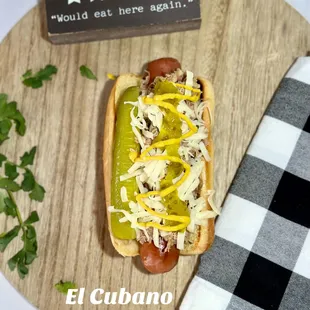 a hot dog with mustard, onions, and cheese