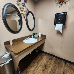 two sinks and a trash can