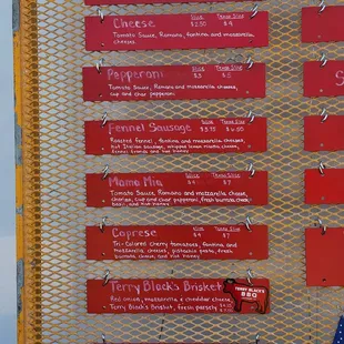 Close up of the Pizza menu, you can see prices by the slice starting at $2.50 up to approx. $7.