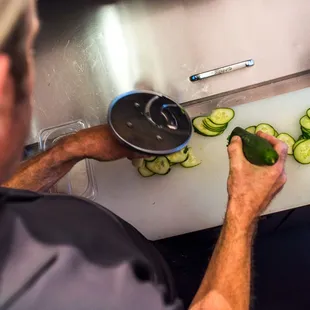 a man slicing cucumbers