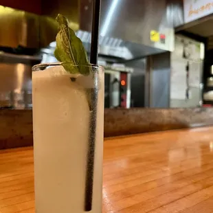 a tall glass with a mint leaf garnish