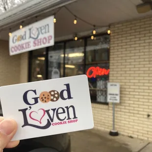 a hand holding a good l&apos;oven cookie shop sticker