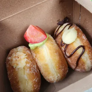 a hand holding a box of doughnuts