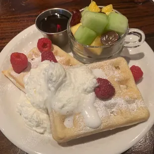 a plate of waffles and fruit