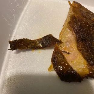 a piece of meat in a styrofoam container