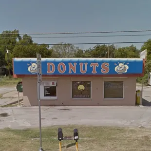 two parking meters in front of a donut shop
