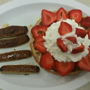 a waffle with strawberries and whipped cream