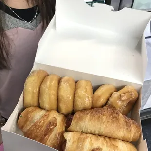 a woman holding a box of donuts