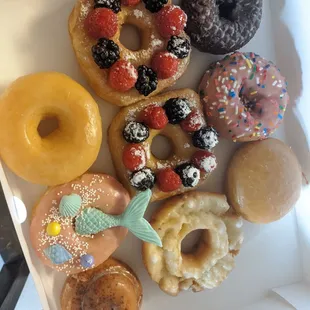 Cronuts w/ berries, mermaid donut w/ white chocolate tail, jelly filled, mini cinnamon roll, old fashioned, devil's food
