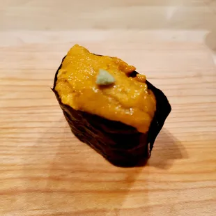 a piece of sushi on a cutting board