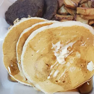 Pancakes and sausage and home fried potatoes and orange juice