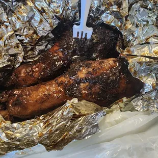 a fork sticking out of a piece of meat wrapped in foil