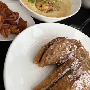 French toast with powdered sugar, bacon and shrimp and grits