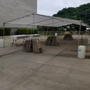 20x40 white canopy with water barrels.