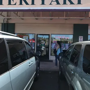 two cars parked in front of a restaurant