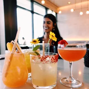 a woman sitting at a table with drinks
