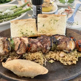 Mesquite grilled skewer over seafood rice with shrimp empanada