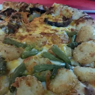 Half pot roast pizza and half tater tot pizza.