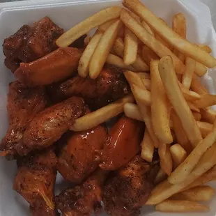chicken wings and fries in a styrofoam container