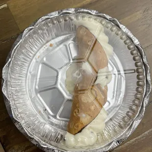 a piece of pizza on a foil plate