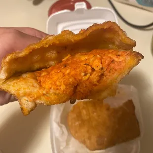 a hand holding a fried chicken sandwich