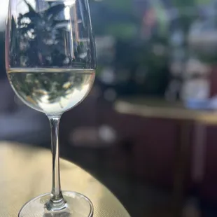 a glass of white wine on a table