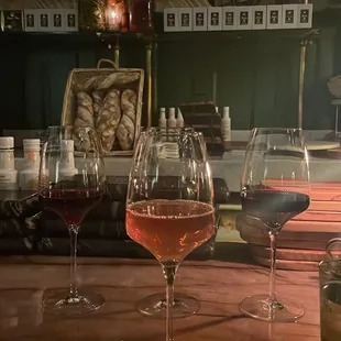 three glasses of wine on a bar